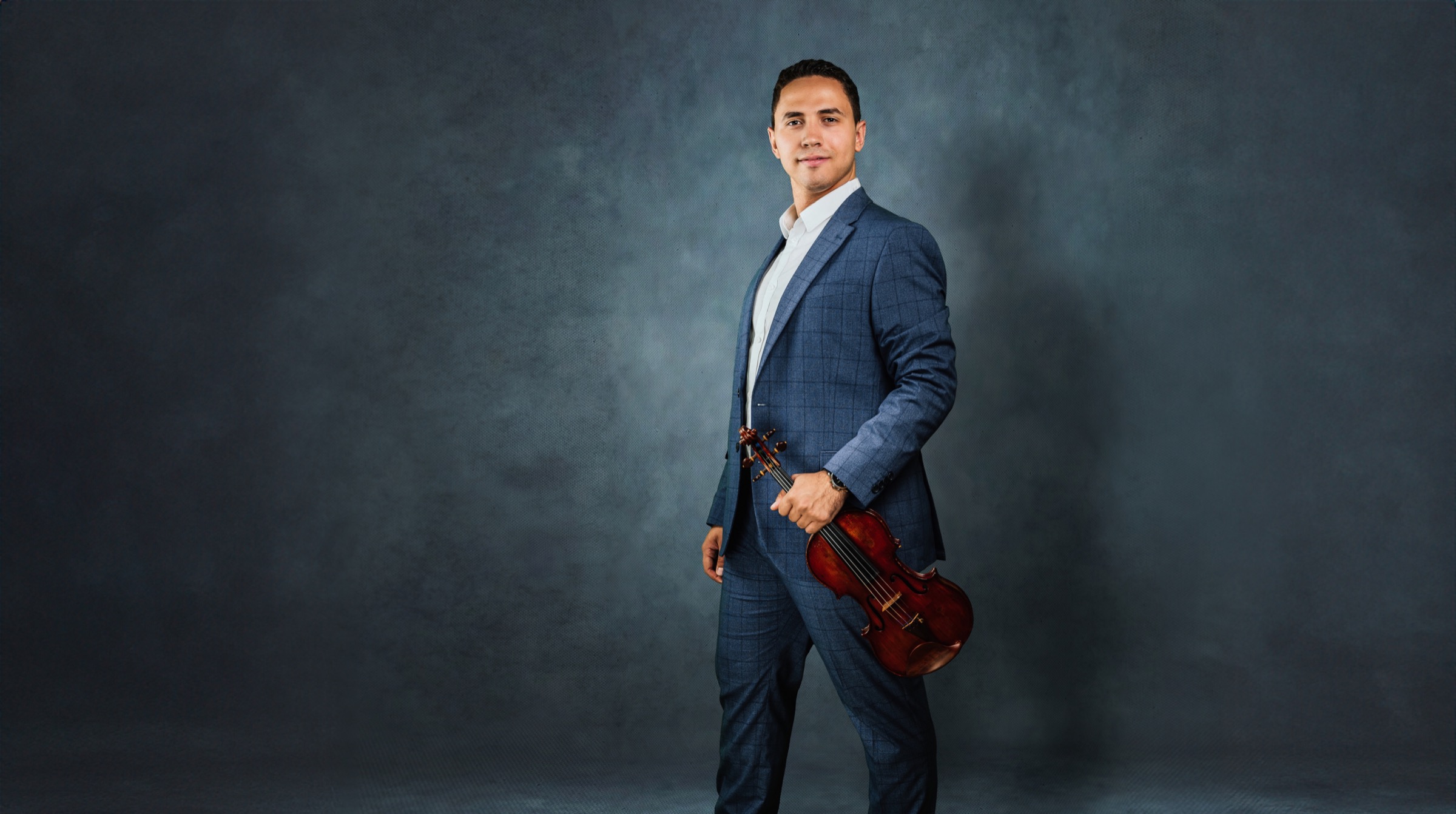 Ocimar Correa Filho in a blue suit holding his violin